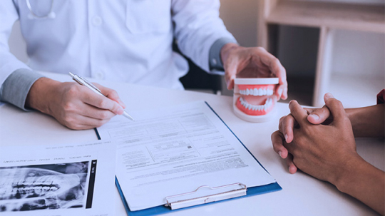 Dentist Reviewing Consultation Notes with Patient